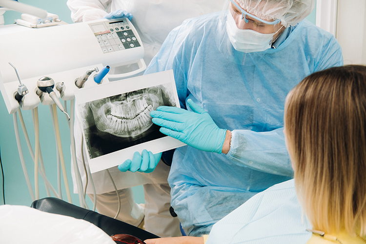 Dentista mostrando radiografía, quistes maxilares en Vinaròs.